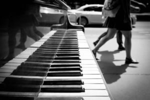 low-section-people-walking-by-grand-piano-sidewalk -