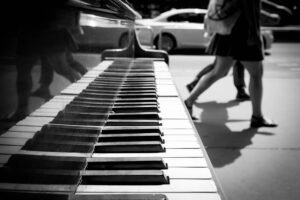 low-section-people-walking-by-grand-piano-sidewalk