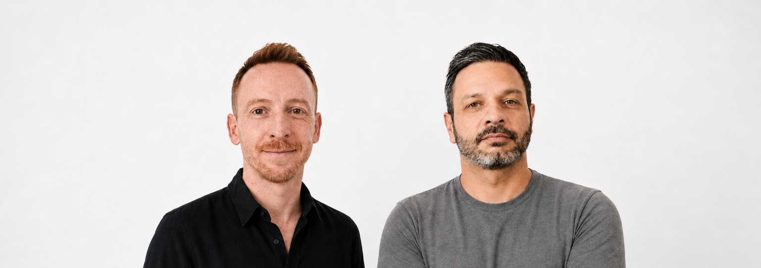 Two men posing against light gray background